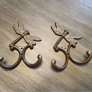 Set of two cast-iron dragonfly double hugs. Painted metallic gold/bronze. NWOT.